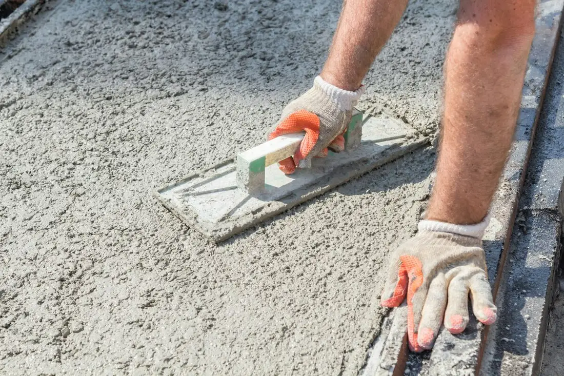 Acabados profesionales en construcción de vivienda — TPD Construcción Albañil aplicando aplanado con llana