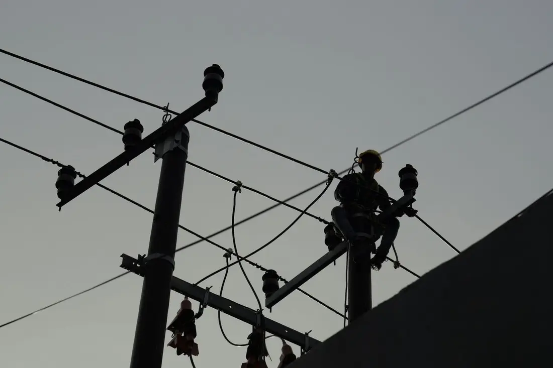 Linieros trabajando en postes de distribución eléctrica