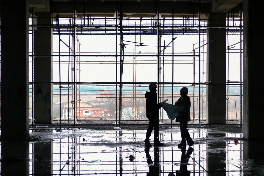 Siluetas de trabajadores sobre andamios